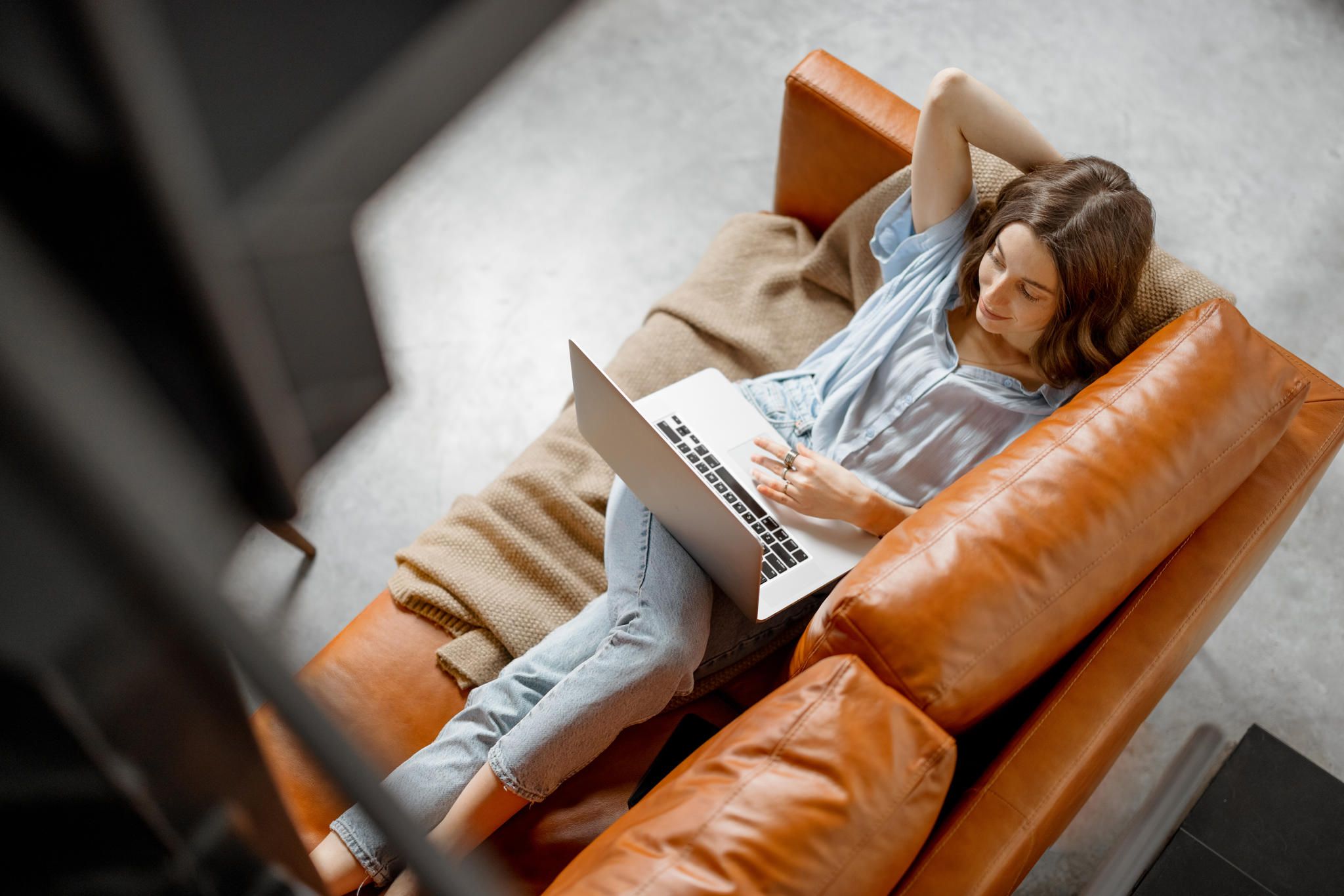 zdjęcie: zrelaksowana kobieta na kanapie z laptopem