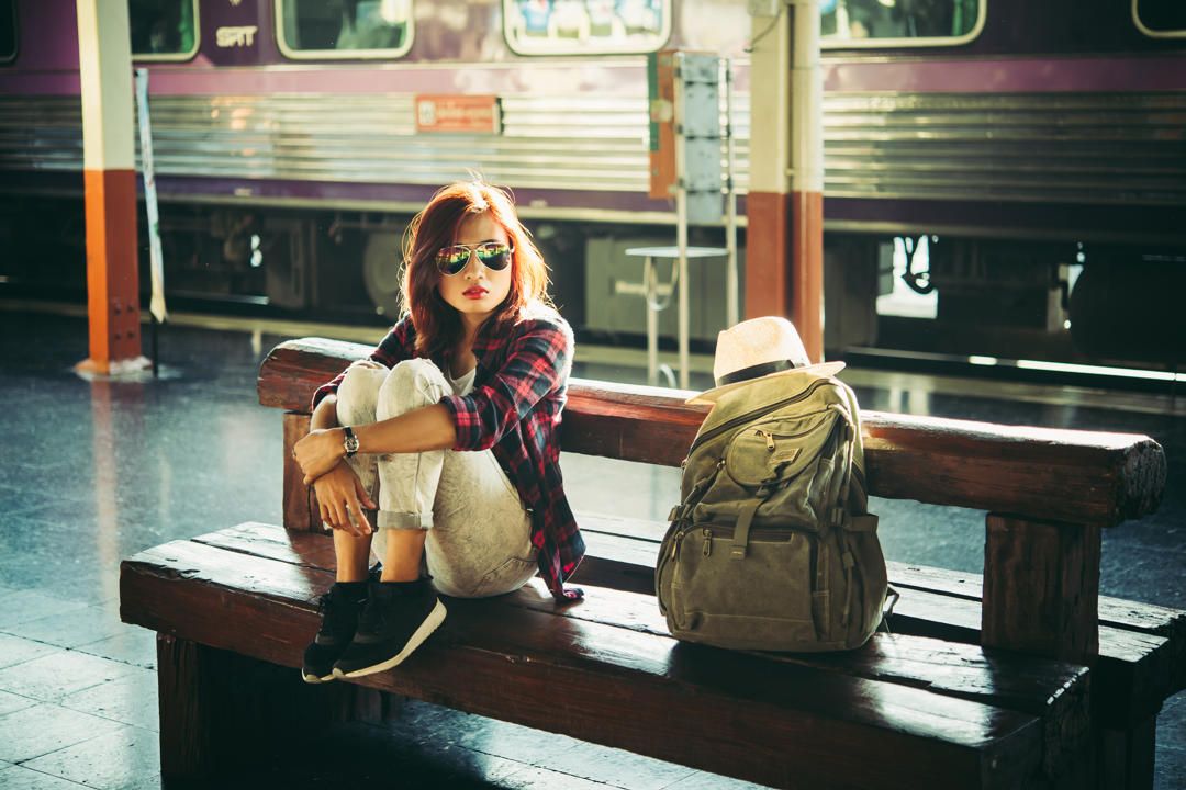 grafika: pani w okularach na peronie czeka na pociąg